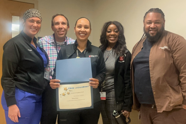 Elvira Urena (center left) celebrates her Exceptional Employee Award with her colleagues.