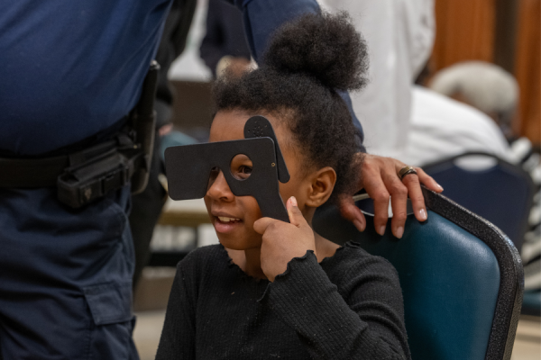 A young community member undergoes a vision screening at the health fair.