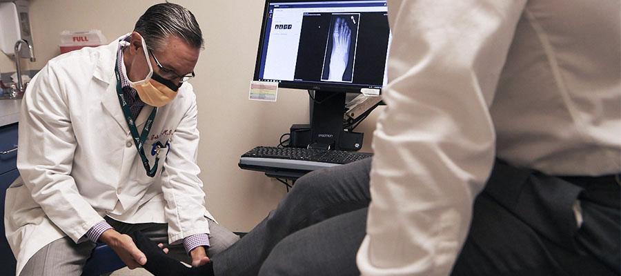 Dr. Eric Gokcen evaluating a patient's foot for injury