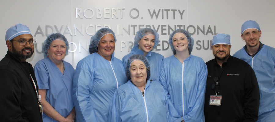 Nancy Witty and medical team in front of sign