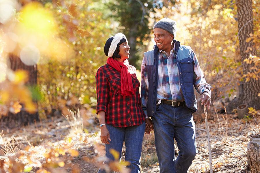 Senior African American couple walking through woods