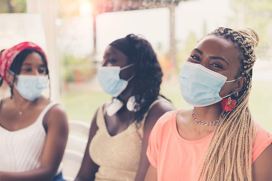 Three African American girls wearing face masks
