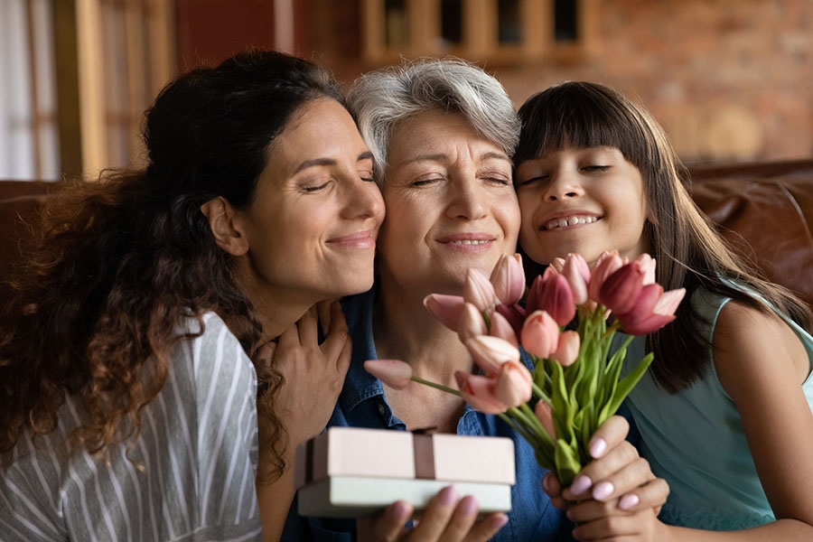 Grandmother, mother and daughter holding flowers