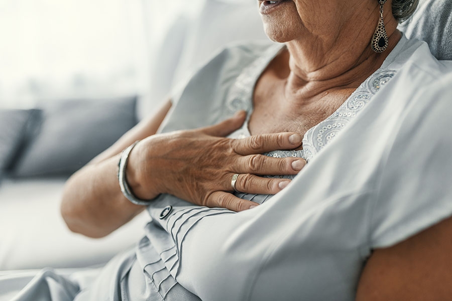 Woman holding chest in pain