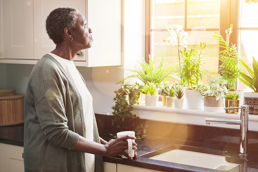 Woman holding coffee, looking out the window