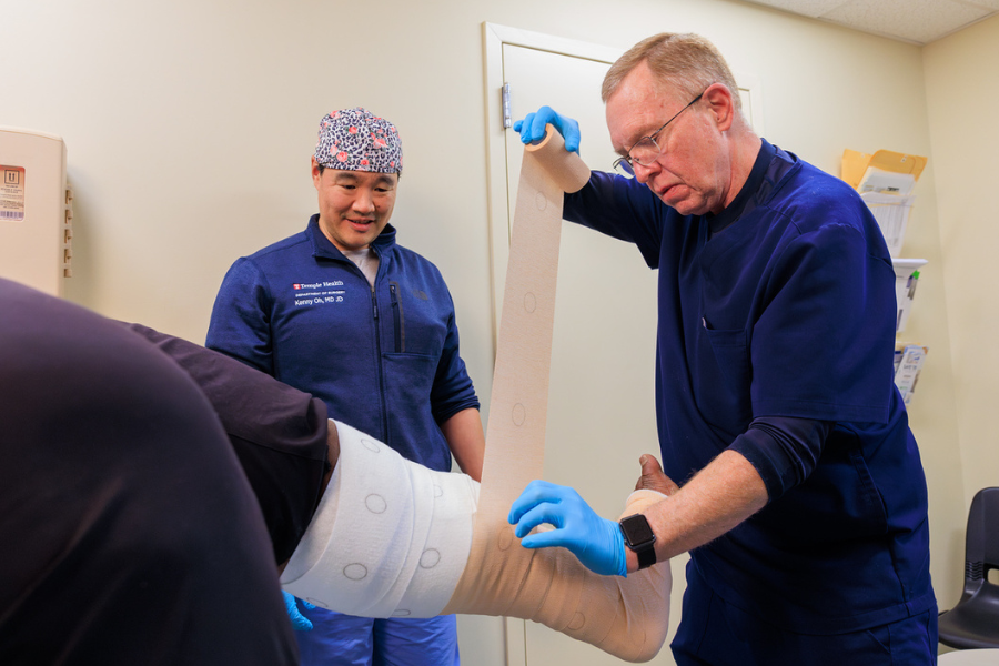 Fitzgerald (right) wraps a wound using a specialized dressing.