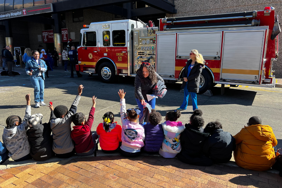 Lougran (center) distributes fire prevention educational materials to students from Mary McLeod Bethune Elementary School. 