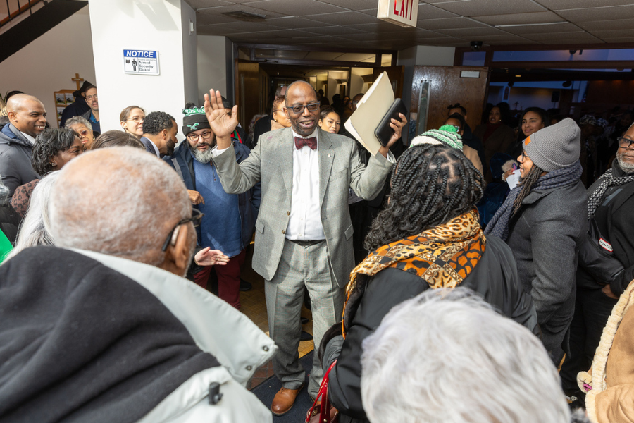 Reverend Major with community members before the start of the ceremony.