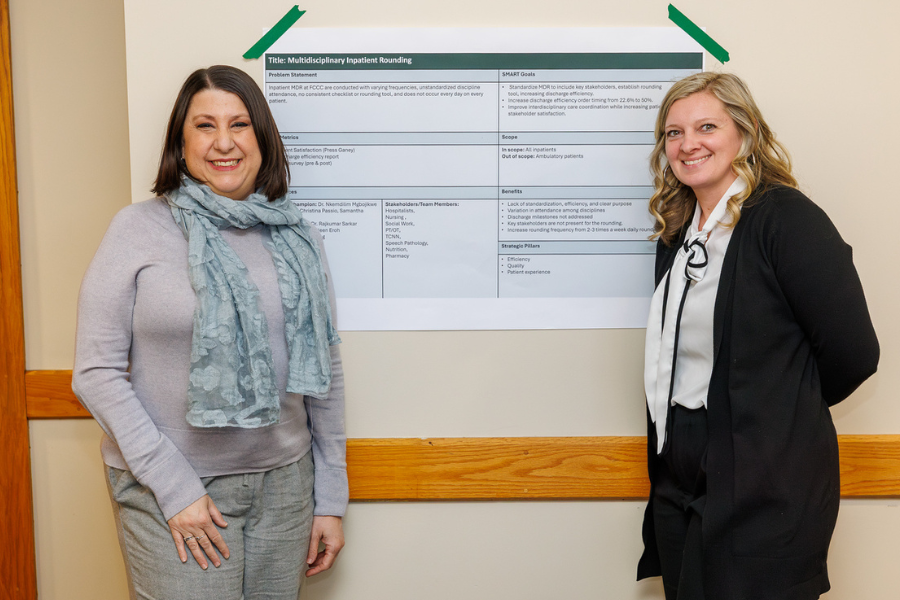 Christina Passion and Samantha Heffron with the poster for their project, "Multidisciplinary Approach to Inpatient Rounding."