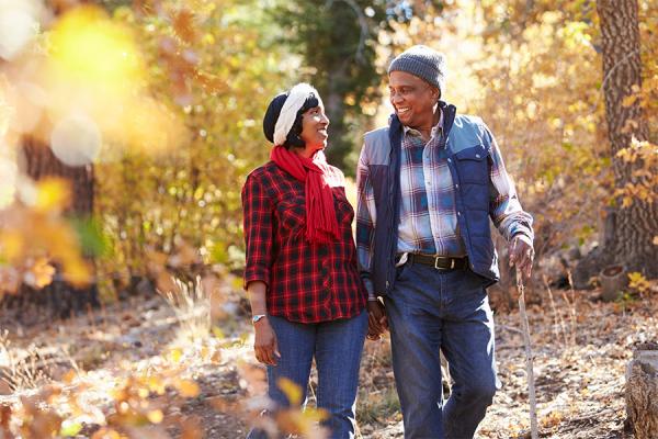 Senior African American couple walking through woods