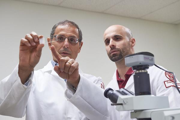 Dr. Pratico examining lab slide