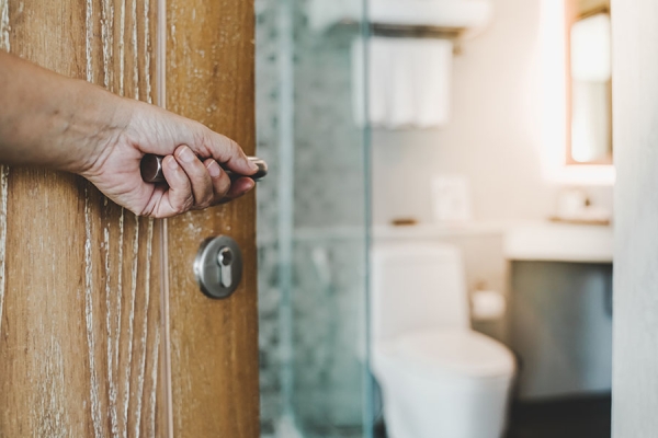 Man's hand opening bathroom door