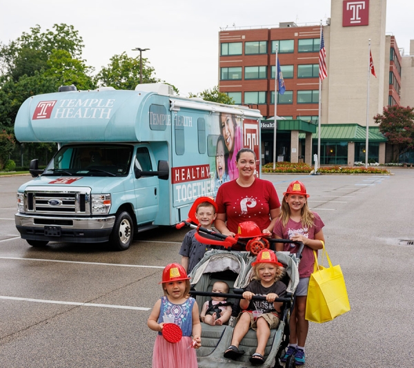 Local family in front of Mobile Health Vehicle