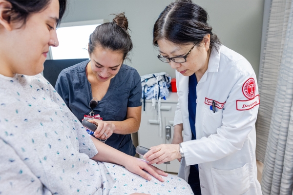 Dr. Sussman-McCrea and Dr. Hsu examine a patient at the screening