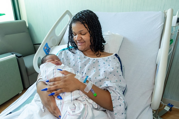 Joelina's mom holding her in hospital bed