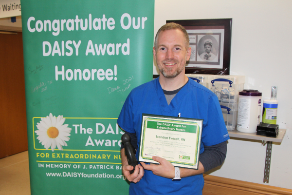 Brandon Everett, RN, with his DAISY Award.