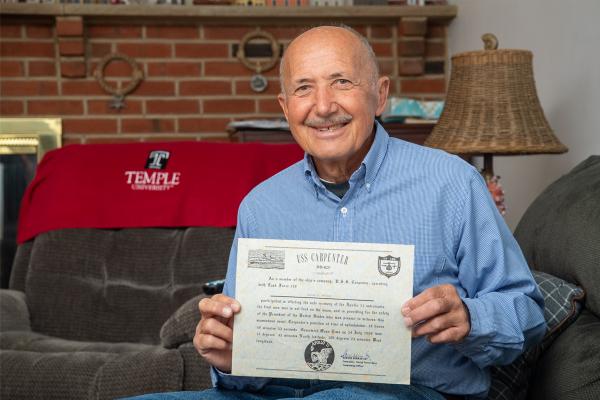 Heart transplant patient Heinz holding his USS Carpenter certificate